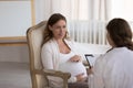 Gynecologist doctor meeting with pregnant patient, asking questions