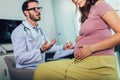 Gynecologist doctor and pregnant woman meeting at hospital Royalty Free Stock Photo