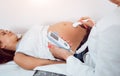 A gynecologist examines a pregnant woman. Fetal doppler heart auscultation.