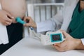 A gynecologist examines a pregnant woman. Fetal doppler heart auscultation