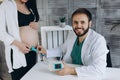 A gynecologist examines a pregnant woman. Fetal doppler heart auscultation