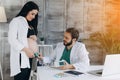 A gynecologist examines a pregnant woman. Fetal doppler heart auscultation