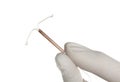 Gynecologist holding copper intrauterine contraceptive device on white background, closeup