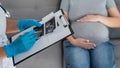 Gynecologist looks at an ultrasound of a pregnant woman. Royalty Free Stock Photo