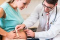 Gynecologist measuring belly of pregnant woman