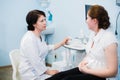 Gynecologist showing ultrasound photo to pregnant woman