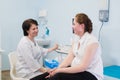 Gynecologist showing ultrasound photo to pregnant woman