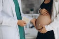 Gynecology consultation. Pregnant woman with her doctor in clinic. Liquor holds pills for a pregnant woman