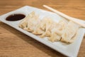 Gyoza (Jiaozi) on white dish with soy sauce