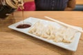 Gyoza (Jiaozi) on white dish with soy sauce