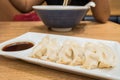 Gyoza (Jiaozi) on white dish with soy sauce