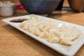 Gyoza (Jiaozi) on white dish with soy sauce