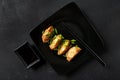 Gyoza - traditional Asian food on a black background with chopsticks and soy sauce, top view