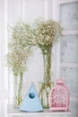 Gypsophila flowers in vases on table. Vintage birdcages, blue birdhouse and gypsophila bouquets in transparent glass vases. Spring Royalty Free Stock Photo
