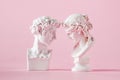 Gypsum antique bust of man and woman on pink background