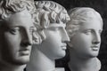 Gypsum copy of ancient statue Apollo, Antinous and Venus head on dark textured background. Plaster sculpture face. Royalty Free Stock Photo