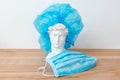 Gypsum copy of David`s head in surgical cap. David plaster bust, ancient sculpture, statue on wooden table with medical Royalty Free Stock Photo