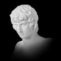 Gypsum copy of famous ancient statue Antinous bust isolated on a black background with clipping path. Plaster antique Royalty Free Stock Photo