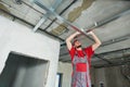 Gypsum plasterboard work. Drywall construction at home. Contractor worker installing metal frame on ceiling Royalty Free Stock Photo