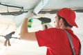 Gypsum plasterboard work. Drywall construction at home. Contractor worker installing metal frame on ceiling Royalty Free Stock Photo