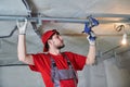 Gypsum plasterboard work. Drywall construction at home. Contractor worker installing metal frame on ceiling Royalty Free Stock Photo