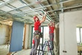 Gypsum plasterboard work. Drywall construction at home. Contractor worker installing metal frame on ceiling Royalty Free Stock Photo