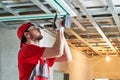 Gypsum plasterboard work. Drywall construction at home. Contractor worker installing metal frame on ceiling Royalty Free Stock Photo