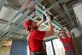 Gypsum plasterboard work. Drywall construction at home. Contractor worker installing metal frame on ceiling Royalty Free Stock Photo