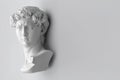 Gypsum statue of David`s head. Michelangelo`s David statue plaster copy on grey background with copyspace for text. Ancient gree