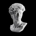 Gypsum statue of David`s head. Michelangelo`s David statue plaster copy isolated on black background. Ancient greek sculpture,