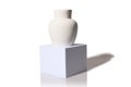 Gypsum white vase on a square white podium. On a white background.