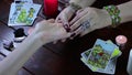 A Gypsy fortune teller reads her hand by candlelight and Tarot cards. The palmist tells fortunes by the lines of the hand.