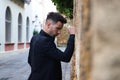 Gypsy man dancing flamenco, young and handsome, dressed in black, leaning angrily on a wall with his fist. Flamenco cultural Royalty Free Stock Photo