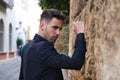 Gypsy man dancing flamenco, young and handsome, dressed in black, leaning angrily on a wall with his fist. Flamenco cultural Royalty Free Stock Photo