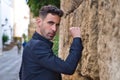 Gypsy man dancing flamenco, young and handsome, dressed in black, leaning angrily on a wall with his fist. Flamenco cultural Royalty Free Stock Photo