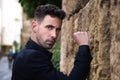 Gypsy man dancing flamenco, young and handsome, dressed in black, leaning angrily on a wall with his fist. Flamenco cultural Royalty Free Stock Photo