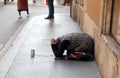 gypsy woman asking for alms kneeling on the ground with her hand