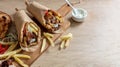 Gyro pita Shawarma wrap on wood table. Greek food with slice cut meat, overhead Royalty Free Stock Photo
