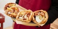 Gyro pita Shawarma, sliced meat tzatziki and vegetable wrap in male hand, close up view Royalty Free Stock Photo