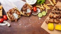 Gyro pita, shawarma, souvlaki. Two pita bread wraps and meat skewers on wooden table Royalty Free Stock Photo