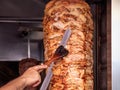 Gyros, doner. Man`s hands holding a knife, cutting slices