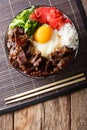 Gyudon beef with rice, egg and onion closeup in a bowl on the ta