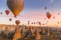 GÃÂ¶reme, Cappadocia, Turkey - October 7 2019: Hot air balloons filled with tourists during a pink sunrise floating along valleys