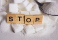 H pile of white sugar cubes and stop word in block letters as advise on addiction calories excess and sweet unhealthy food abuse c Royalty Free Stock Photo