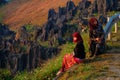 Ha Giang / Vietnam - 01/11/2017: Two local Vietnamese women in traditional clothes looking at the sunrise and mountain scenery in