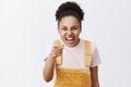 Ha-ha you are ugly. Portrait of rude impolite female bully with dark skin in yellow overalls, expressing scorn and Royalty Free Stock Photo