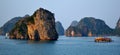 Limestone karsts and fishing boat in the evening sun Halong Bay Royalty Free Stock Photo