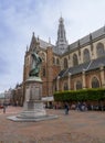 Haarlem/Holland - October 06 2019: People walking and cycling in city center with Statue of Laurens Janszoon Coster