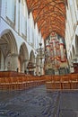 The interior of St Bavokerk Church, with a wooden vaulted ceiling, the organ built by Christian Muller in 1738 and gravestones