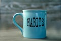 HABITS - word on a blue cup on a dark background